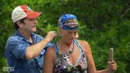 Jeff Probst placing the Immunity Necklace around Holly's neck.