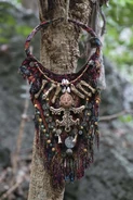 Panama A large necklace made of cloth, beads, artifacts and a carved face.