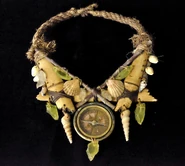 Worlds Apart A necklace of shells, green stones and wood surrounding a compass.