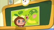 Ms. Perfect pointing out Tamagotchi Town on a map of Tamagotchi Planet, from the anime Tamagotchi! episode 139