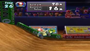 Mametchi taking on the Waluigi Cup's challenge; jumping from ramps with a 70 Meter goal. A couple more of the Tamagotchi advertisements described above can be seen in the background.