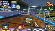 Mametchi racing in his Standard Kart on Waluigi Stadium. A couple of the Tamagotchi advertisements described above are on the top left.