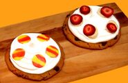 Two sets of completed ice cream cookie pizzas.