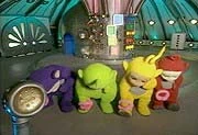 The Teletubbies cleaning their feet with the Tubby Sponges
