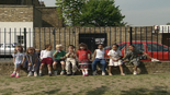 Nine children sitting on the wall.