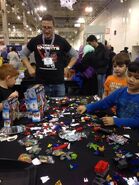 A Tenkai Knights representative watching the children build at the ChiTAG Fair of 2013.