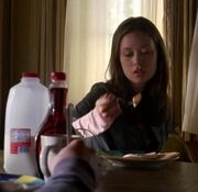 Cameron eats a pancake while Derek watches.