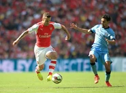 Jack Wilshere and Jesus Navas fight for the ball