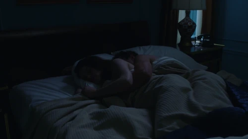 Cuddling in bed, after having had sex.