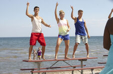 Eldon dances atop a table at the beach.