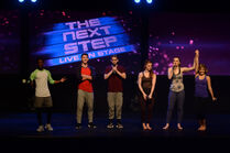 Lamar, Trevor, Isaac, and Jordan stand on-stage as Logan declares Brittany the winner of the trick-off.