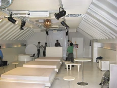 View of the other half of Bianco, showing the DJ console, screen and central row of square bed-seats.