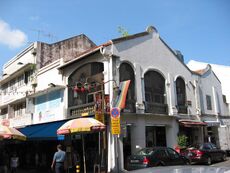 View of Backstage Bar, on the upper floor, proudly displaying the rainbow flag, from the corner of Trengganu and Temple Streets.