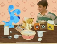 Spatula put three bananas into bowl.