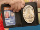 Provenza showing his badge and ID-card (with what appears to be a less than flattering ID photograph)