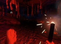 The player holding a flare in a cave