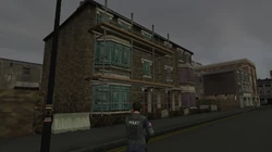 Side view of Rivington Street Crackhouse in The Getaway: Black Monday, the barrier on the left prevents you from going around the back of the building.