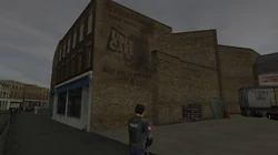 Writing on a wall in front of the Used Car Yard that is advertising the business.