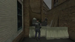 The back of the Yardie Drug Factory seen from the alleyway in The Getaway: Black Monday. Barriers prevent you from approaching.