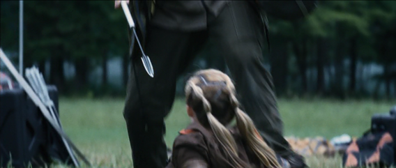 Marvel in front of the District 7 female as he is about to spear her.