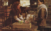 Katniss buying liquor from Ripper in The Hunger Games: Catching Fire.