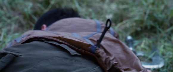 Katniss sees the knife sticking out of his back.