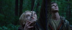 Glimmer apuntando con el arco a Katniss.jpg