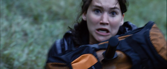 Clove throws another knife at Katniss' head, but blocks it with her backpack.