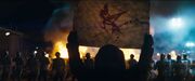 A silhouetted person raising up the symbol of the mockingjay.