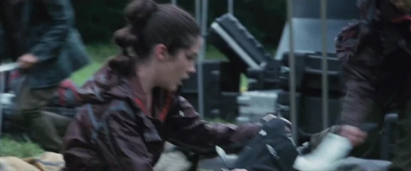 District 4 female has just sliced the District 3 female's legs as Clove obtains some throwing knives (middle) and the District 5 male grabs a sickle off the floor (right).