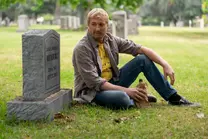 Johnny sits at his mother's grave while drinking.