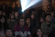 Children watching a film in the mess hall.