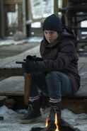 Ellie in an abandoned shack with Joel's rifle.