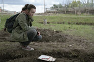 Ellie leaves Sam's magic slate on his grave.