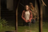Ellie and Tess walk through the flooded part of the hotel.