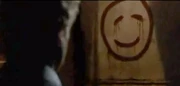 Patrick betrachtet das Zeichen von Red John, neben dem toten Panzer
