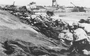 As soon as it hit the beach on the right side of the V Amphibious Corps line, the 25th Marines was pinned down by accurate and heavy enemy fire. Meanwhile, landing craft, supplies, and vehicles pile up in the surf behind Marines. Department of Defense Photo (USMC) 110108