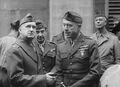 20 June 1942-Wellington Harbor, New Zealand. MajGen Vandegrift (wearing overcoat), and BrigGen Rupertus (center), confer dockside after debarkation. Still image from USMC motion picture film