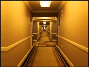 The photo of a hallway in a hotel. Far at the end is the Slender Man.