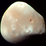 The smaller and more irregular-shaped of the two moons, Deimos.