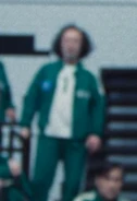 Player 411 watching Gi-hun's violent crash out with Seon-nyeo.