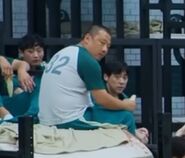Player 032 staring at Jang Deok-su and Seong Gi-hun