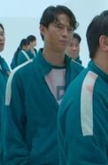Player 357 watching Jang Deok-su and Han Mi-nyeo before Tug of War