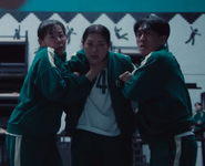 Player 306 looks at Gi-hun in shock after he strangled Seon-nyeo.