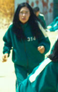 The female Player 314 running behind Player 365 and Cho Sang-woo before crossing the finish line