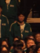 Player 344 as the guards explain that the prize money will increase with every elimination.