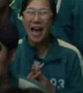 Player 193 with her hair tied and glasses cheering that the games are over.