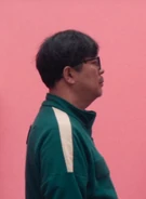 Mistake where the screen cuts to Yong-sik and Geum-ja, 048 taking his photo at a booth here