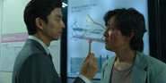 The Recruiter giving Gi-hun the Squid Game invitation card.