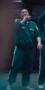 Player 442 whistling and mocking Gi-hun after Team O won the vote.